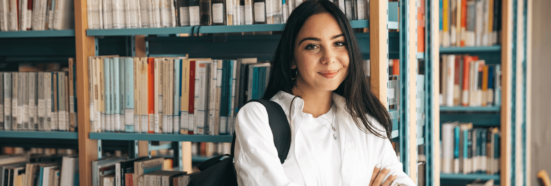 C'est une image d'une étudiante internationale devant une bibliothèque de livres